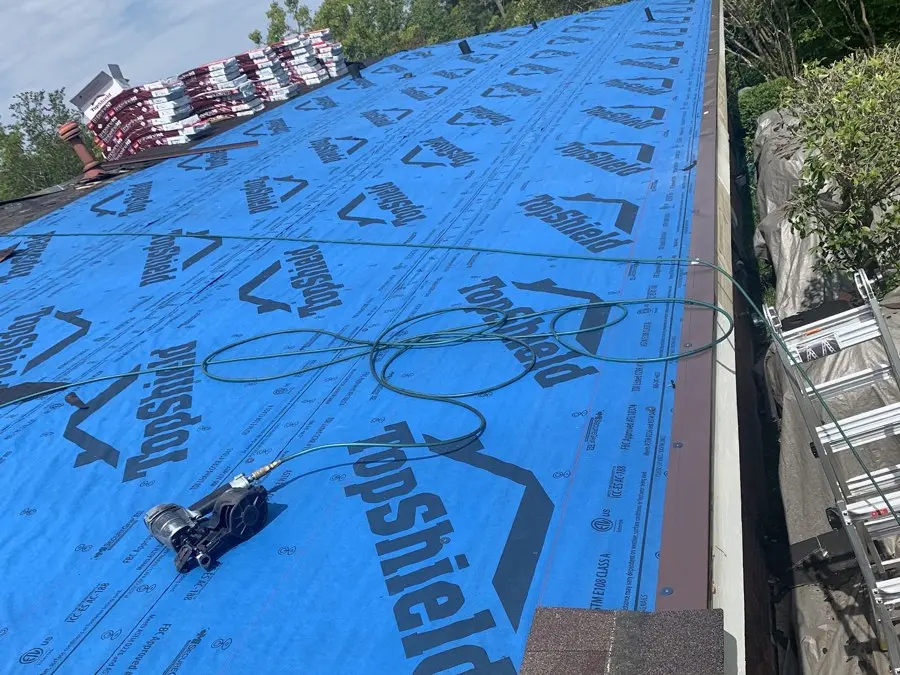 Blue synthetic underlayment going down on a roof